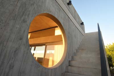 Casa Acacias: Abertura circular y escalera exterior de hormigón